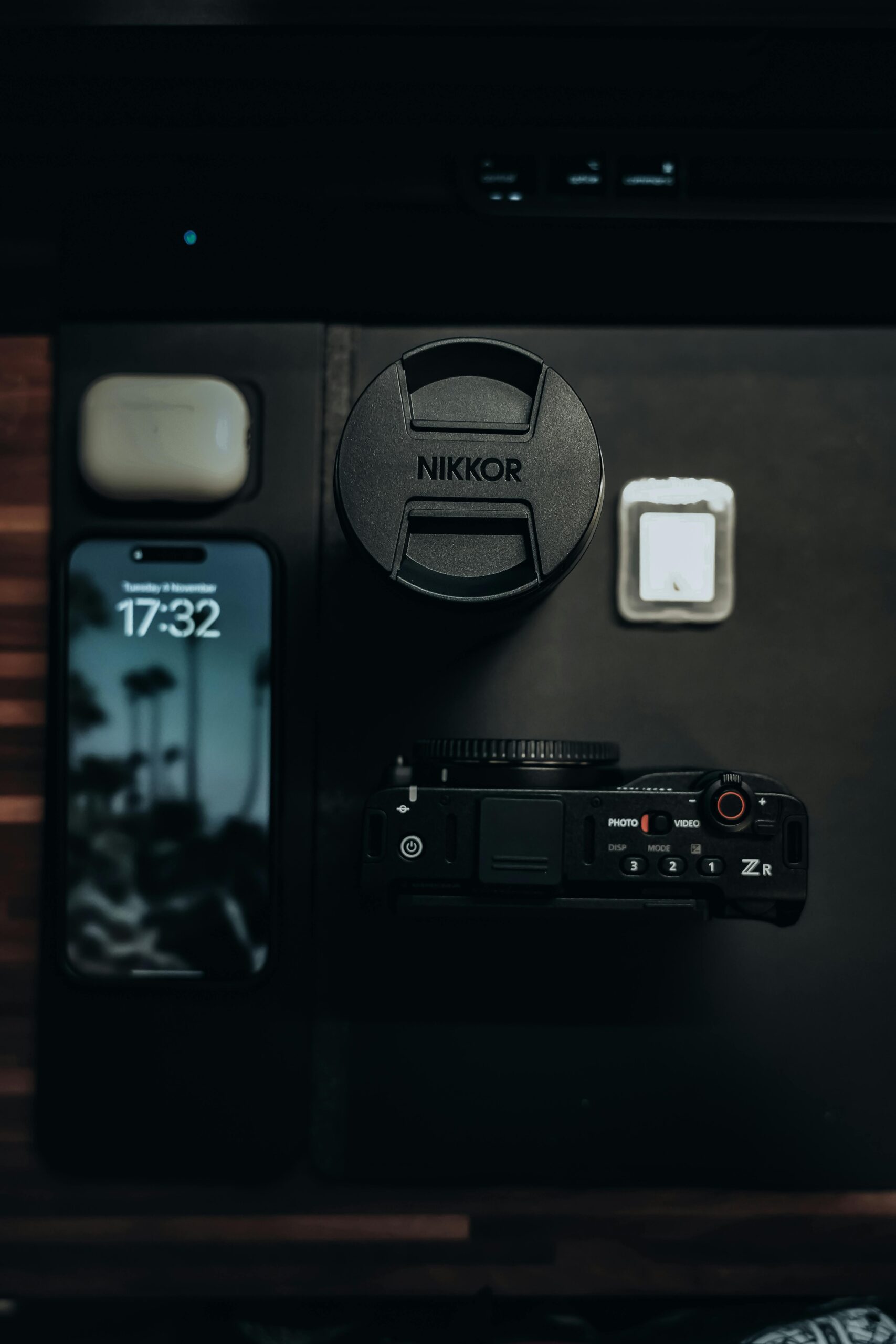 Discover a moody flat lay featuring photography gear and tech gadgets, perfect for creatives.
